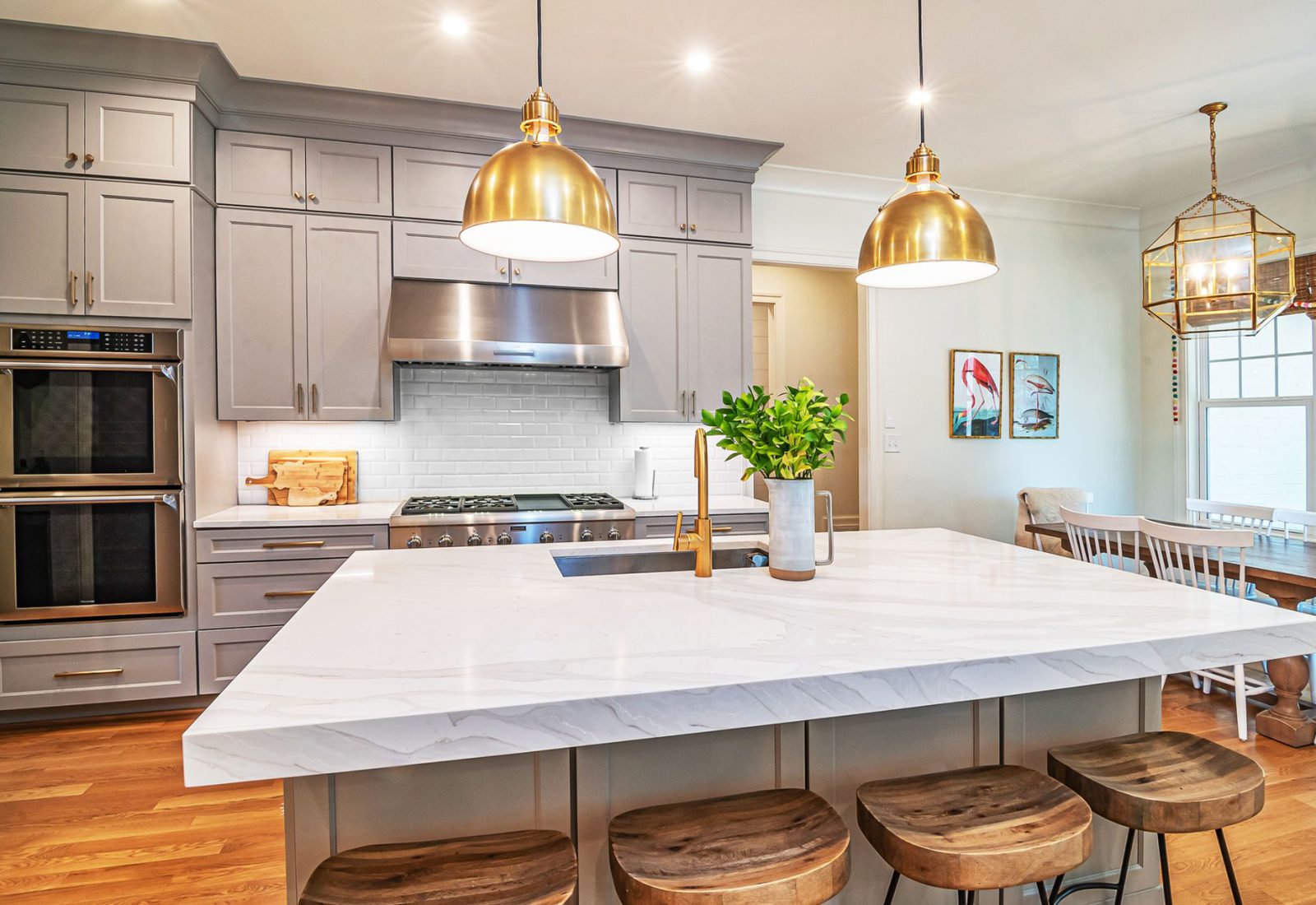 Bright modern kitchen with a large island, bar stools and brass pendant lights